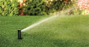 Pop-up sprinkler head watering a lush green lawn, providing efficient irrigation for healthy grass in Cincinnati, OH