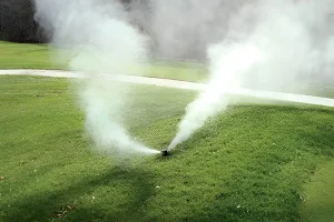 Sprinkler system releasing mist during winterization in Cincinnati, OH, showing how frozen irrigation pipes and valves can fail without proper maintenance.