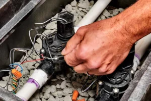 A technician repairs an underground sprinkler valve to restore proper water flow and keep a residential irrigation system operating efficiently.