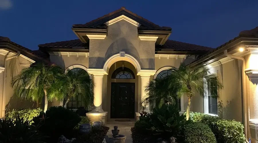 Front of a luxury home illuminated with frost-resistant landscape lighting in Northern Kentucky at night