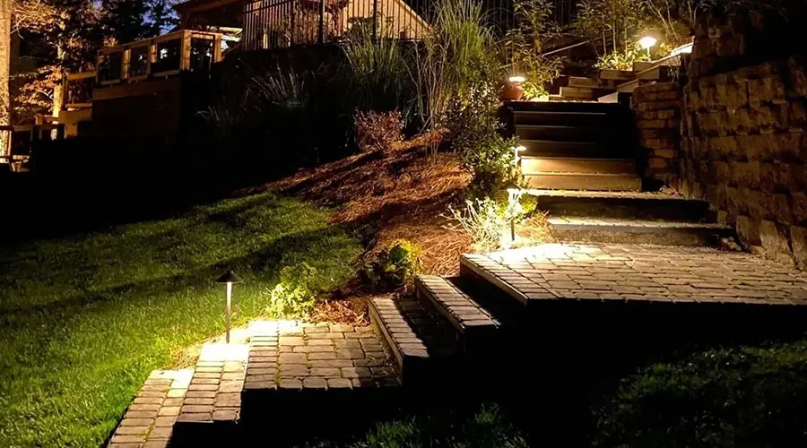 Pathway lighting company in Northern Kentucky installing low-voltage LED lights along steps and walkway for safer nighttime visibility and curb appeal