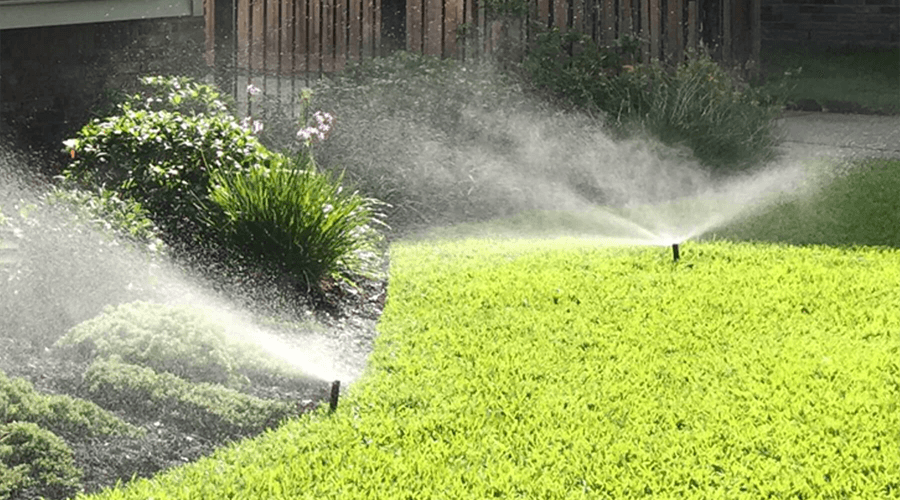 Sprinkler system watering in a green beautiful lawn