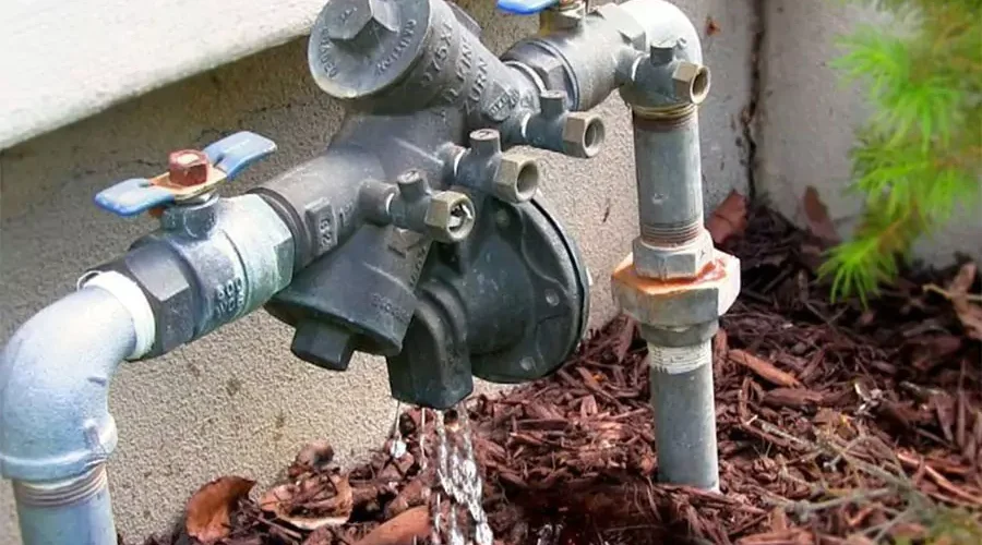 Leaking backflow preventer with water dripping from a faulty valve, highlighting the importance of backflow testing for protecting Cincinnati's drinking water supply.