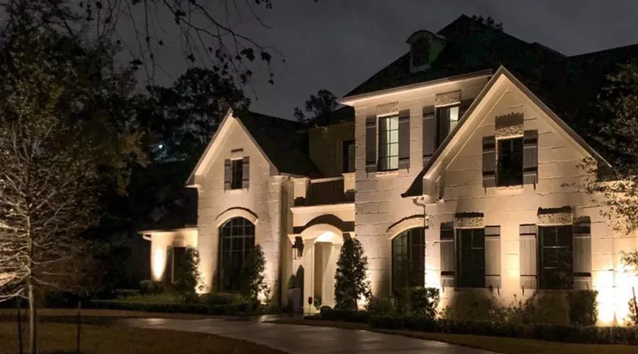 Elegant two-story home illuminated with warm architectural outdoor lighting installation in Kentucky, enhancing curb appeal and nighttime safety.