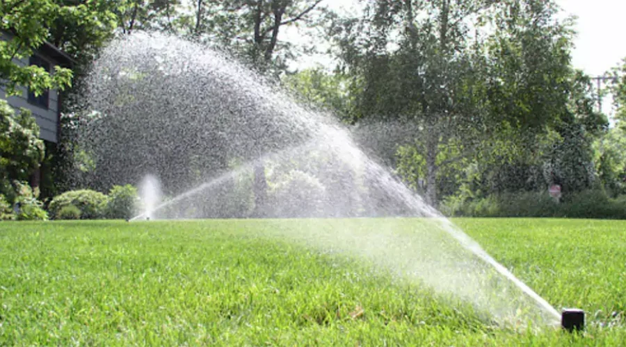 Sprinklers watering lush green lawn - understanding the impact of seasonal changes on your sprinkler system's performance in Cincinnati, OH.