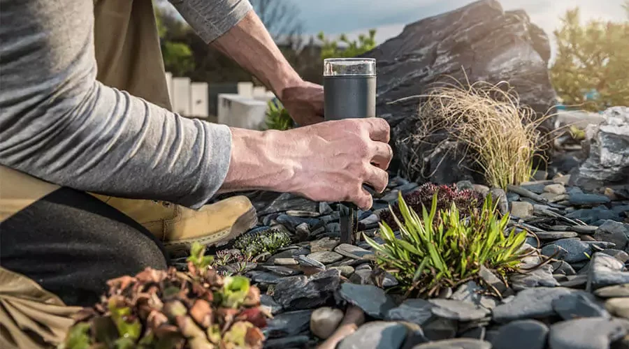 A man installing outdoor lights in a garden