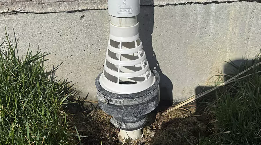 Installed freeze guard for sump pump drain to prevent winter pipe damage