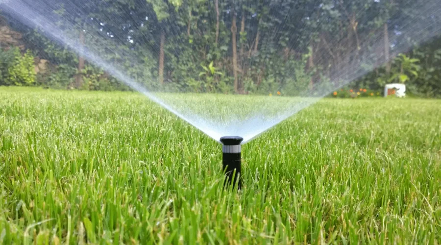 Sprinkler system watering in a green beautiful lawn